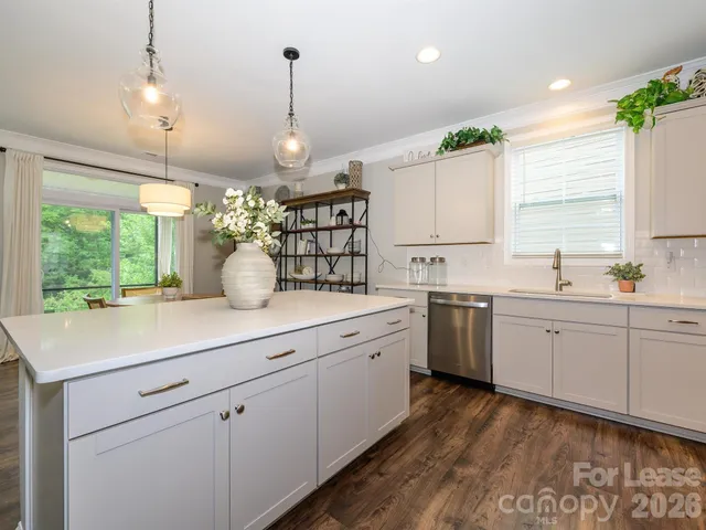 a kitchen with white cabinets and window