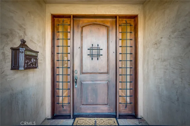 a view of a hallway with wooden door and front door
