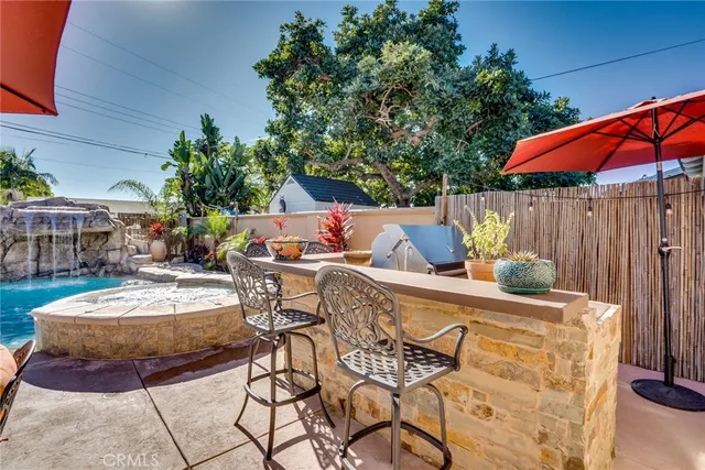 a view of a patio with table and chairs under an umbrella