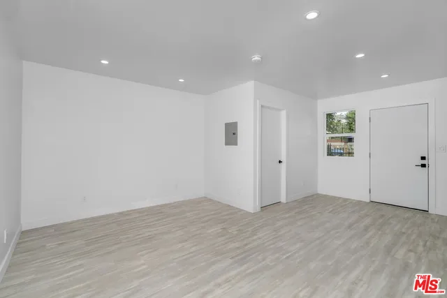 a view of an empty room with wooden floor