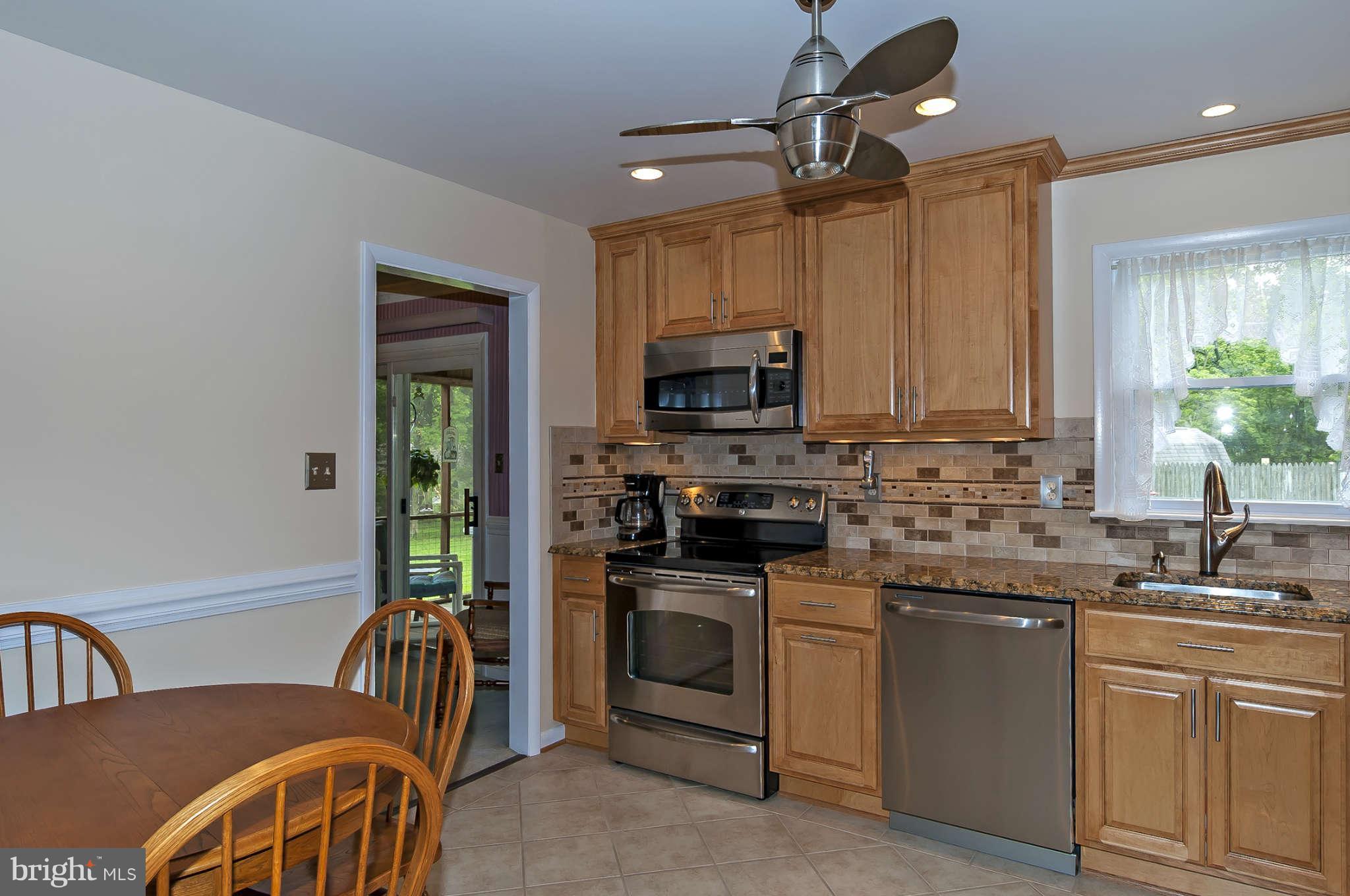 12955 Triadelphia Mill Road Clarksville, MD 21029 - Photo 10 of 29 a kitchen with stainless steel appliances granite countertop a sink a stove a refrigerator a microwave oven with white cabinets and a granite counter top