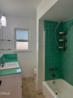 a bathroom with a sink a toilet a window and vanity