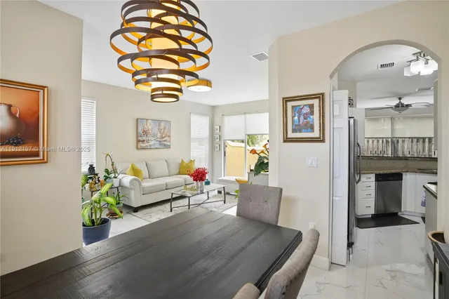 a living room with furniture a fireplace and a chandelier