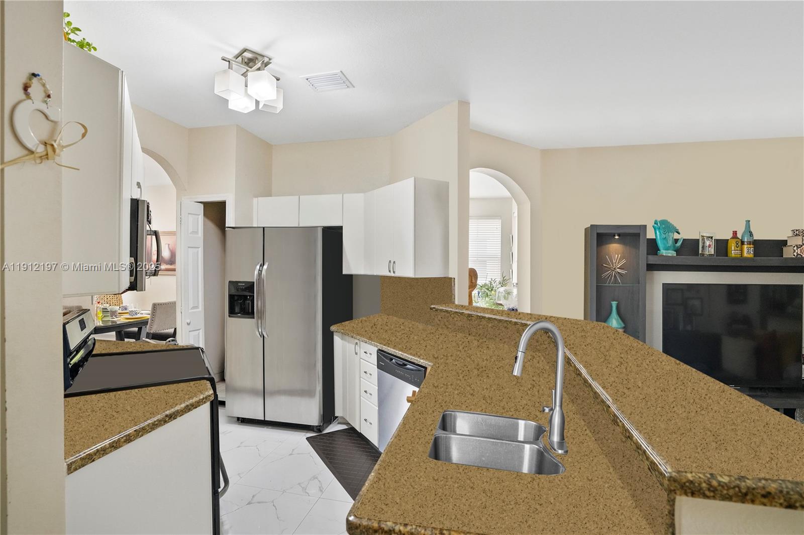 11753 Southwest 137th Path Miami, FL 33186 - Photo 24 of 33 a kitchen with stainless steel appliances granite countertop a refrigerator a sink dishwasher a stove and a dining table with wooden floor