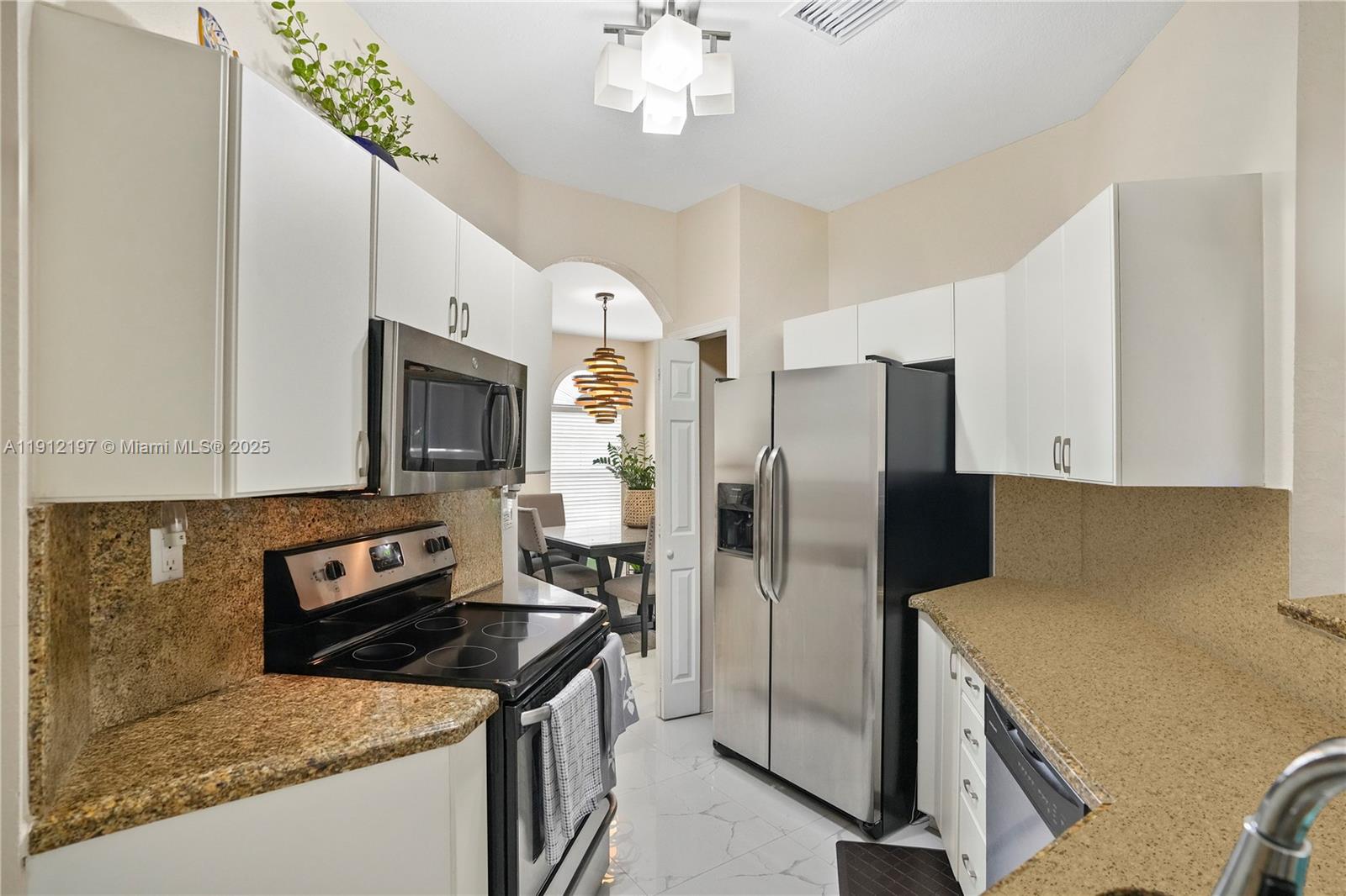11753 Southwest 137th Path Miami, FL 33186 - Photo 26 of 33 a kitchen with stainless steel appliances granite countertop a refrigerator a stove and a sink