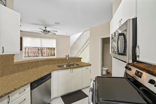 a kitchen with a sink appliances and cabinets