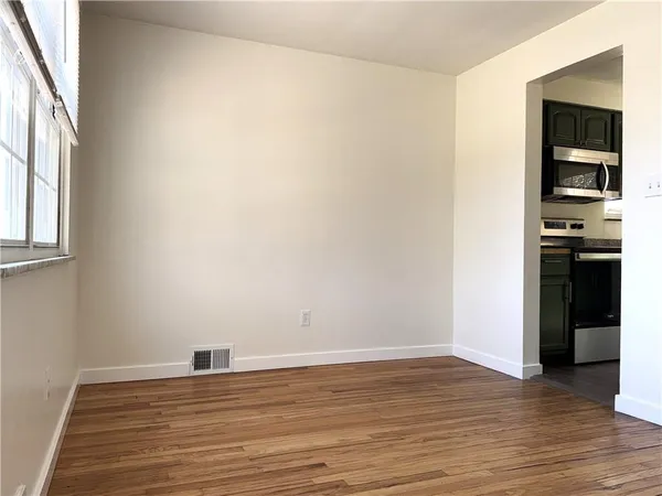 an empty room with wooden floor and closet