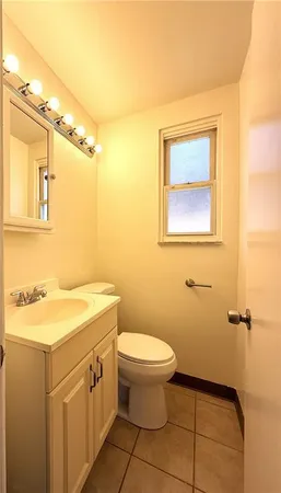 a bathroom with a granite countertop sink mirror vanity and toilet