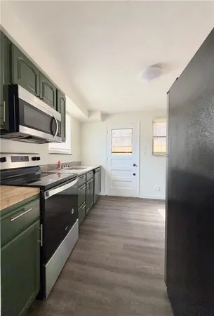 a large kitchen with stainless steel appliances granite countertop a stove and a sink