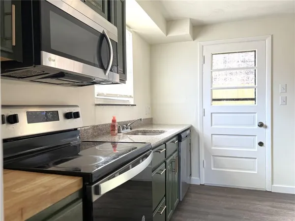 a kitchen with appliances cabinets and a wooden floor