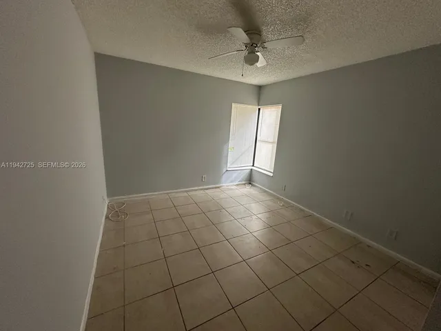 a view of an empty room and chandelier fan
