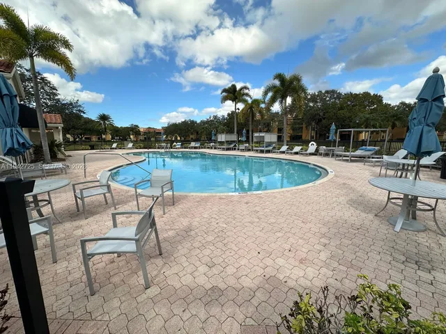 a view of a swimming pool with outdoor seating and plants