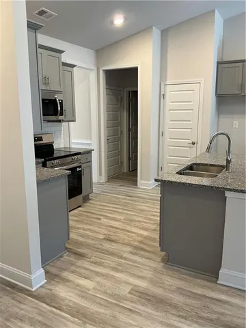 a kitchen with granite countertop a sink stove and refrigerator