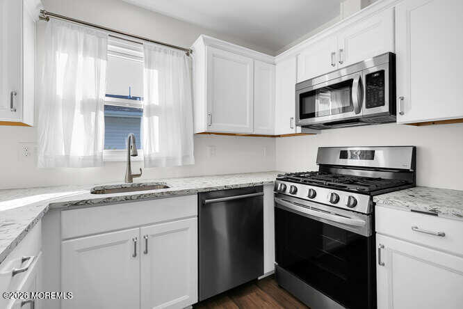 8 Carter Way Brick, NJ 08723 - Photo 5 of 27 a kitchen with stainless steel appliances granite countertop white cabinets and a stove top oven