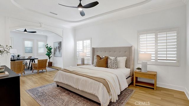 a spacious bedroom with a bed a couch and a potted plant