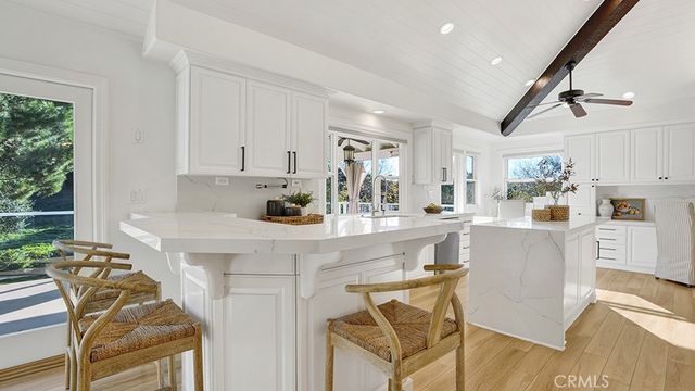 a kitchen with stainless steel appliances kitchen island granite countertop a table chairs and a refrigerator