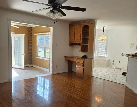 an empty room with a window and a fan