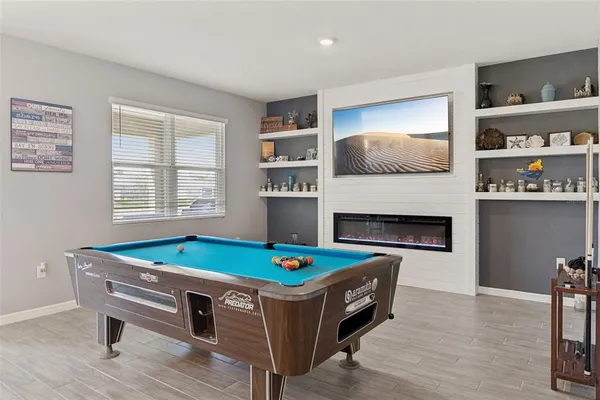 a room with pool table and windows