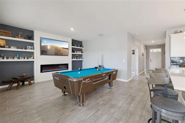 a living room with furniture flat screen tv and chairs
