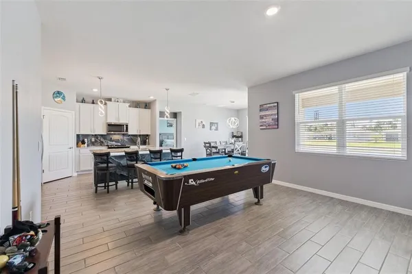 a living room with furniture a dining table and wooden floor