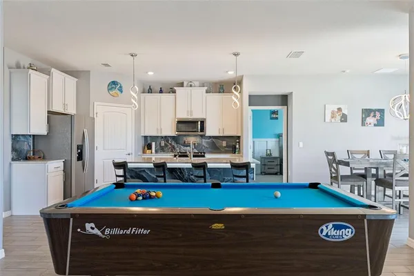 a kitchen with kitchen island stainless steel appliances a sink a stove a refrigerator and cabinets