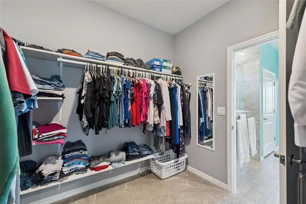 a view of walk in closet with clothes and shoes