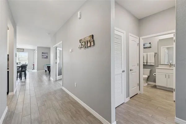 a view of a hallway with bathroom and wooden floor