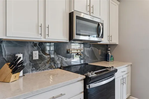 a kitchen with granite countertop a stove and a microwave
