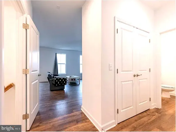 a white toilet sitting next to a white wall