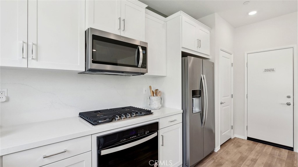 11392 Forge Road Corona, CA 92883 - Photo 8 of 24 a kitchen with stainless steel appliances a stove microwave and cabinets