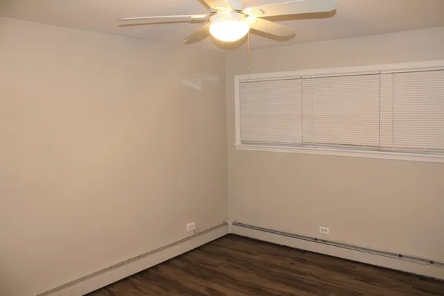a view of a small space with wooden floor and fan