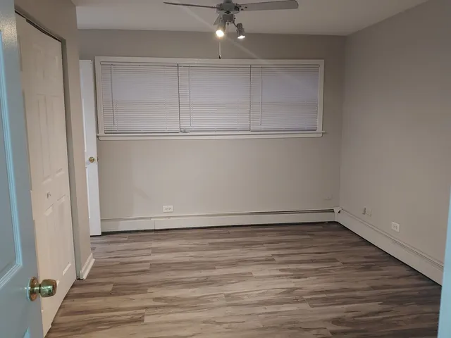 a view of an empty room with wooden floor