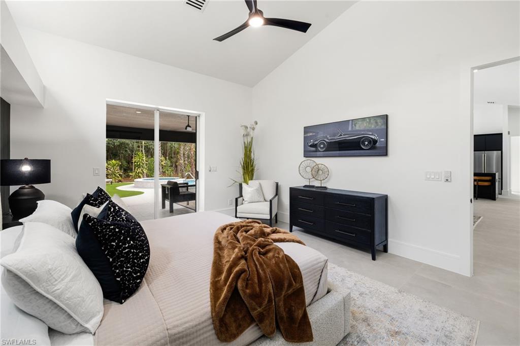 4521 3rd Avenue Northwest Naples, FL 34119 - Photo 16 of 46 a bedroom with furniture a flat tv and a fireplace