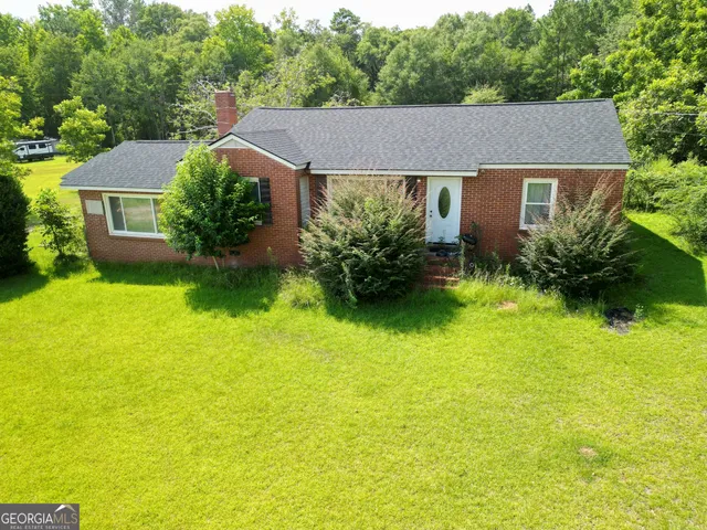a aerial view of a house with swimming pool next to a yard