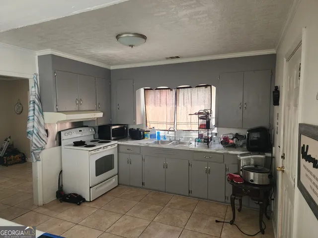 a kitchen with a stove a sink and a refrigerator