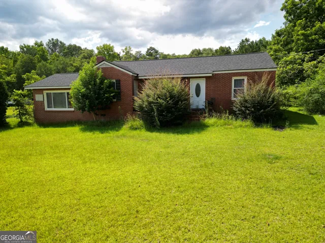 a view of a house with a yard and potted plants