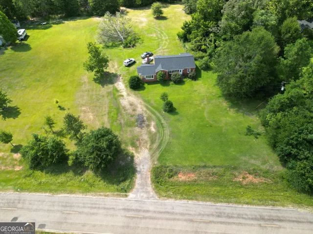 an aerial view of a residential houses with yard