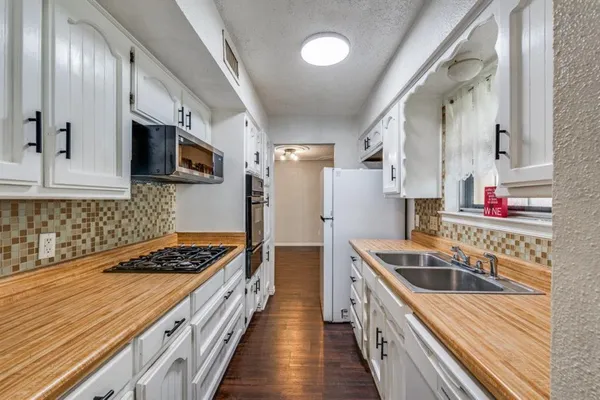 a kitchen with stainless steel appliances kitchen island granite countertop a sink stove refrigerator and cabinets