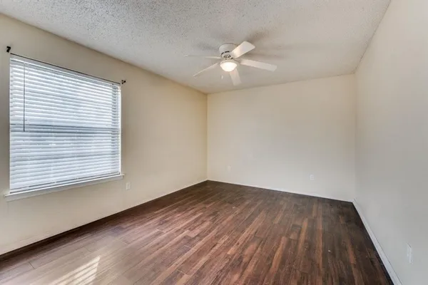 wooden floor in an empty room with a window