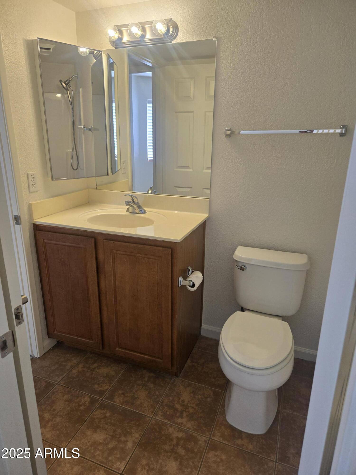 1720 East Thunderbird Road, Unit 2094 Phoenix, AZ 85022 - Photo 22 of 36 a bathroom with a granite countertop toilet a sink and a mirror