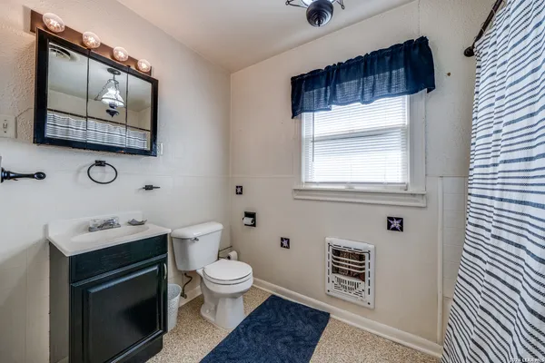a bathroom with a toilet a sink and mirror