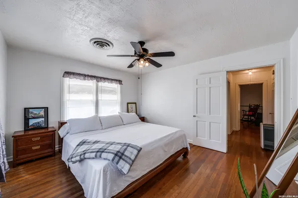 a bedroom with a bed a couch and a chandelier