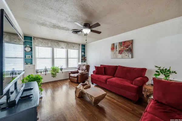 a living room with furniture wooden floor and a large window