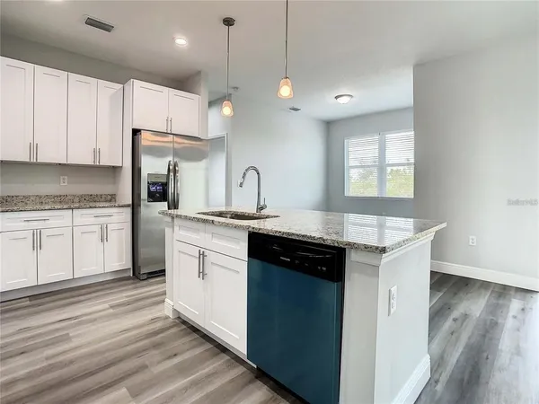 a kitchen with a sink window and cabinets