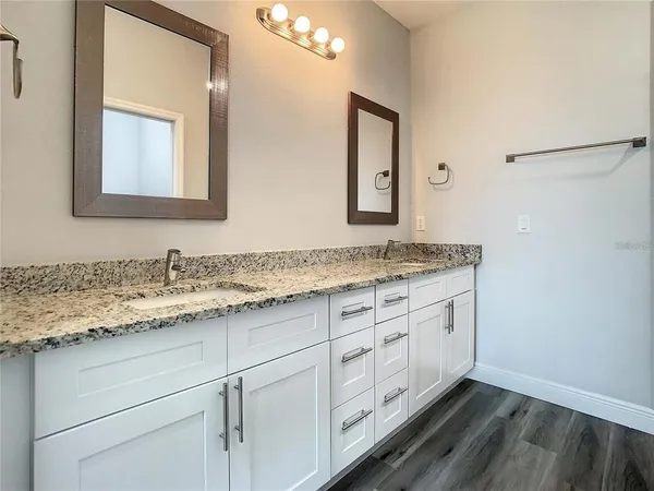a bathroom with a granite countertop sink and a mirror