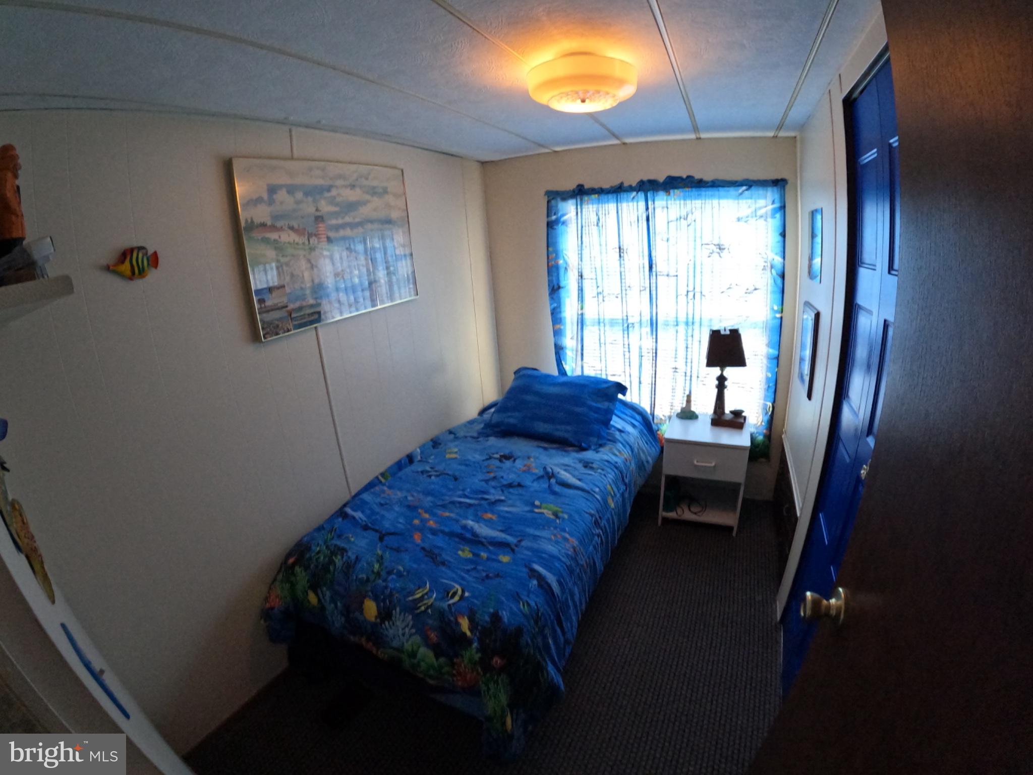 163 Clamshell Road Ocean City, MD 21842 - Photo 9 of 18 a bed sitting in a bedroom next to a window