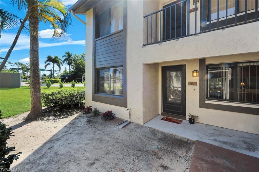 5857 Rattlesnake Hammock Road, Unit 101 Naples, FL 34113 - Photo 3 of 19 Entry-level unit featuring a glass-paneled front door, exterior lighting, and a private upper-level balcony