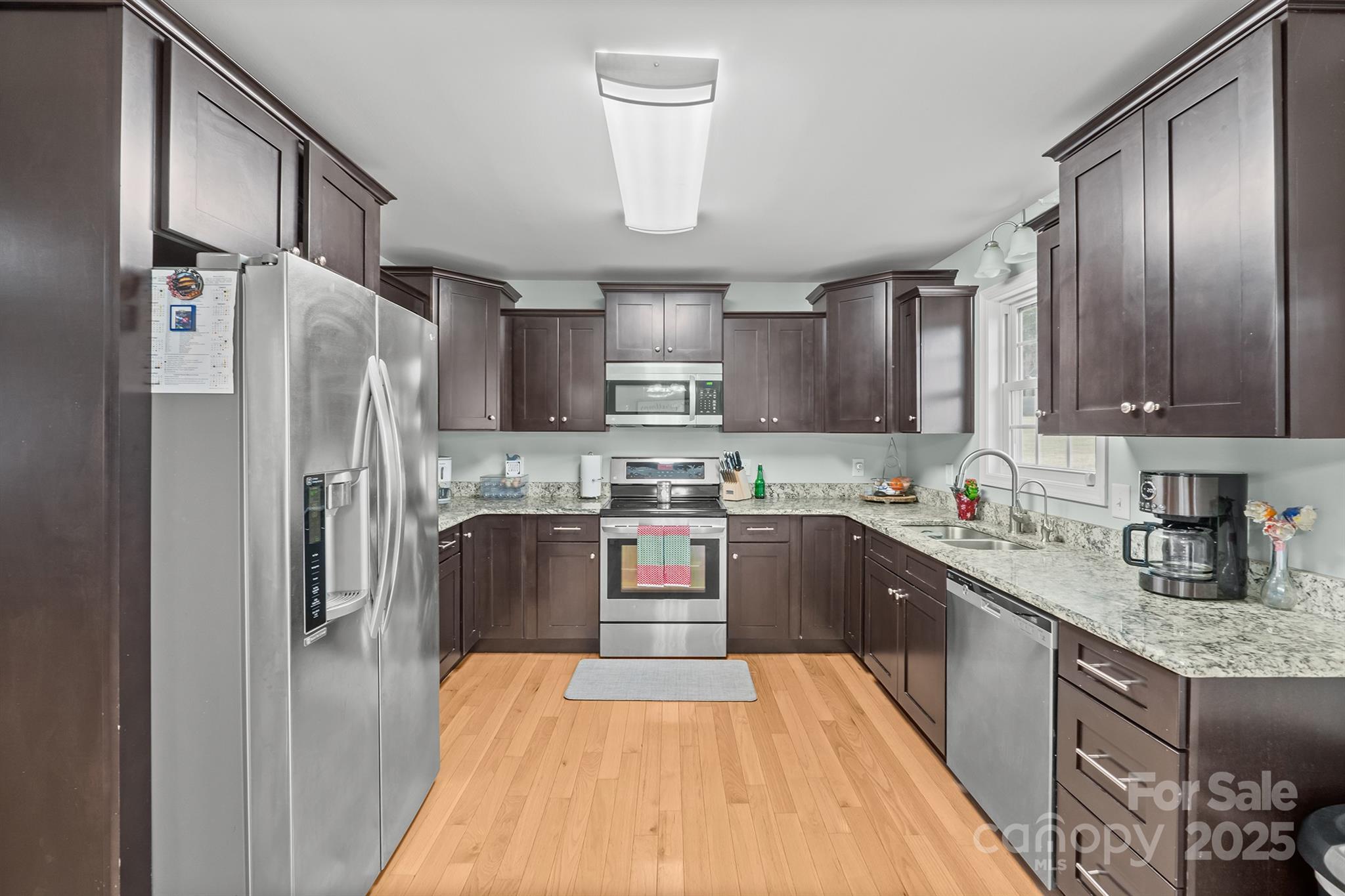 2572 Rock Dam Road Lincolnton, NC 28092 - Photo 15 of 30 a kitchen with stainless steel appliances granite countertop a refrigerator a sink dishwasher a stove with wooden cabinets and floor