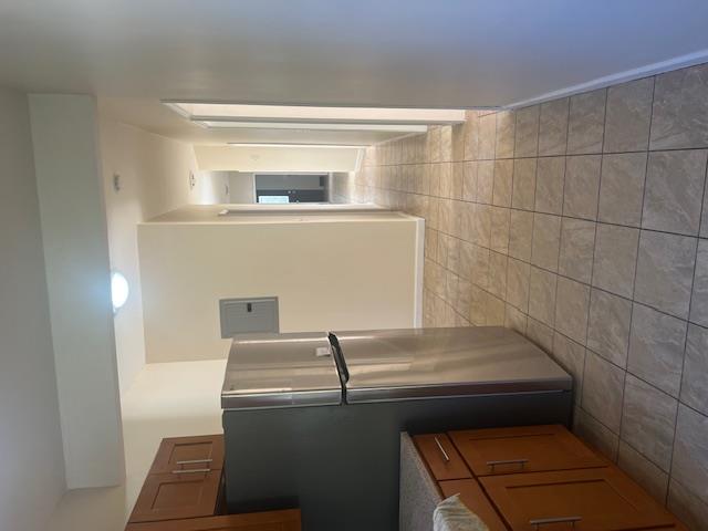 88-40 88th Street Queens, NY 11421 - Photo 15 of 18 Kitchen featuring fridge, electric panel, and light tile patterned floors