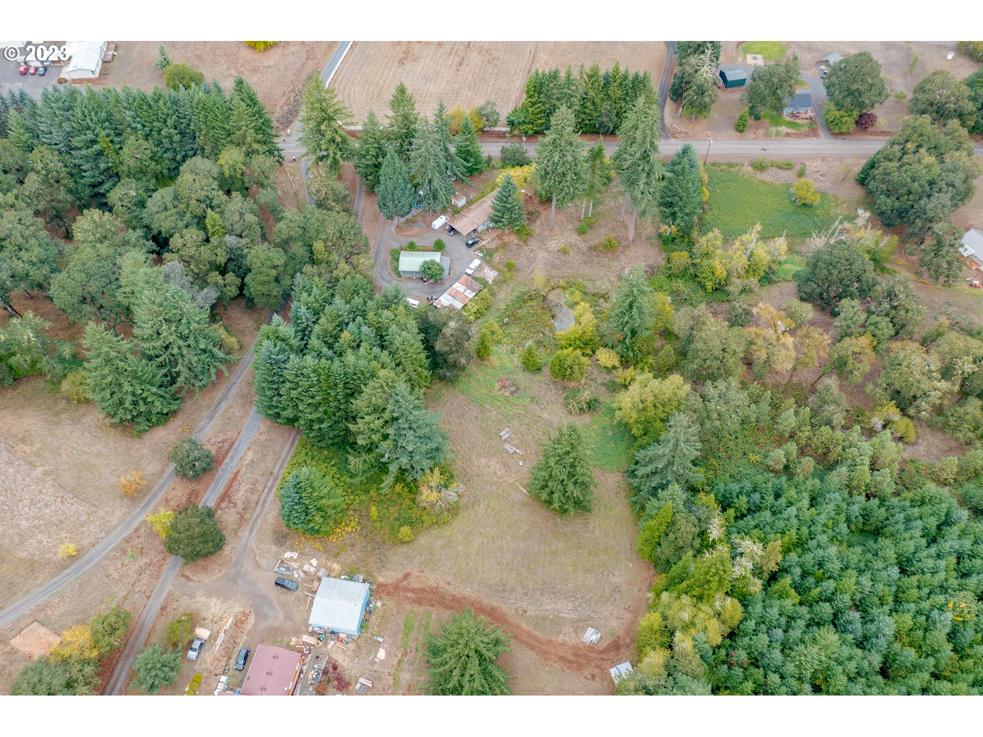 an aerial view of residential house with outdoor space and trees all around